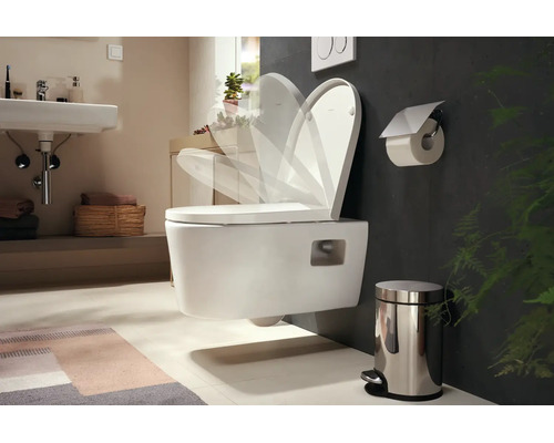 Wandhängende Toilette mit Absenkautomatik in einem modernen Badezimmer mit Waschbecken und Zubehör.