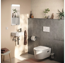 Modernes Gäste-WC mit wandhängendem WC, kleinem Waschbecken, Spiegel mit Beleuchtung und Wandfliesen in Betonoptik.