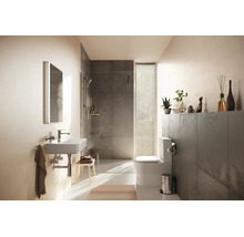 Modernes Badezimmer mit weißem Waschbecken, begehbarer Dusche mit grauen Fliesen und Stand-WC. Hell und strukturiert gestaltet.