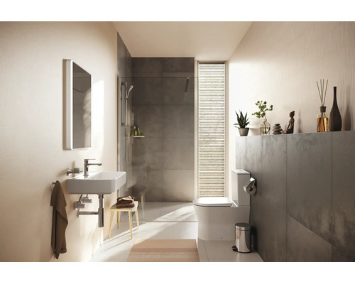 Modernes Badezimmer mit weißem Waschbecken, begehbarer Dusche mit grauen Fliesen und Stand-WC. Hell und strukturiert gestaltet.