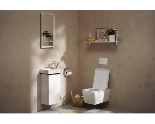 Modernes Gäste-WC mit weißem Wand-Waschbeckenunterschrank, wandhängendem WC und rechteckigem Spiegel vor beigefarbenen Wänden.