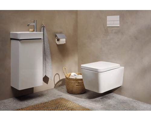 Modernes Bad mit wandhängender Toilette, weißem Waschbeckenunterschrank, Armatur, Toilettenpapierhalter und geflochtenem Korb.