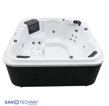 Quadratischer Außenwhirlpool von Sanotechnik mit weißer Innenwanne, schwarzer Verkleidung, Massagedüsen und Kopfstützen.