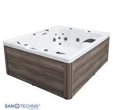 Sanotechnik Außenwhirlpool mit grauer Verkleidung in Holzoptik, weißem Acryl-Innenbecken, Massagedüsen und Kopfstützen.