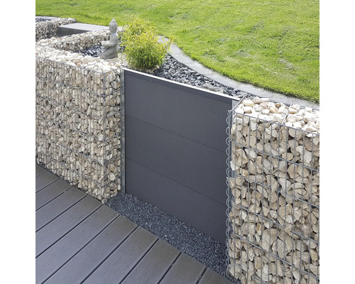 Modern gestaltete Gartenanlage mit Gabionen aus Metallkörben mit Steinfüllung und einem Sichtschutzelement aus Paneelen neben einer Terrasse.