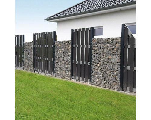 Moderner Gartenzaun aus Gabionen mit grauen Steinen und dunklen vertikalen Sichtschutzelementen auf einer Rasenfläche.