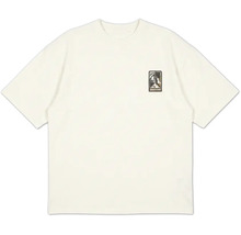 Cremefarbenes Kurzarm-T-Shirt mit Rundhalsausschnitt und kleinem Grafik-Patch auf der linken Brust.