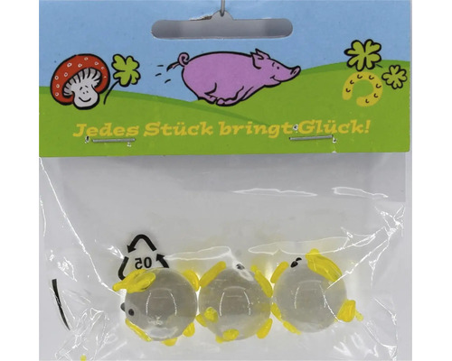 Drei kleine Glasmurmeln mit gelben Verzierungen in einer Verkaufspackung mit der Aufschrift Jedes Stück bringt Glück