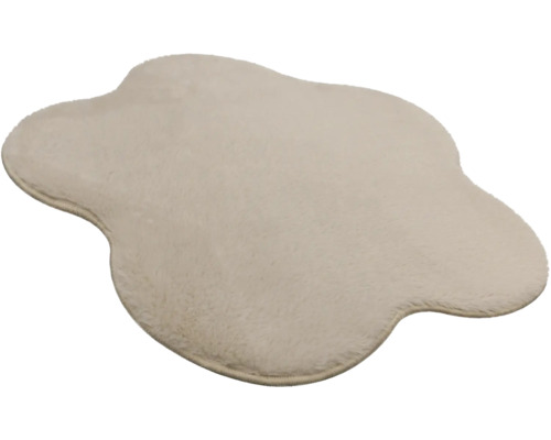 Cremefarbener Kunstfell-Teppich in unregelmäßiger Form mit weichem Flor.