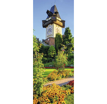 Grazer Uhrturm am Schlossberg in einer Parkanlage mit Blumenbeeten und Bäumen.