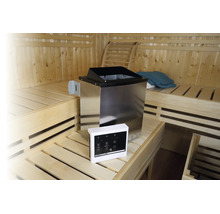 Edelstahl-Saunaofen mit digitaler Steuereinheit in einer hellen Holzsauna mit Sitzbänken auf mehreren Ebenen.