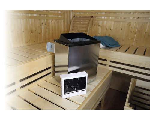 Edelstahl-Saunaofen mit digitaler Steuereinheit in einer hellen Holzsauna mit Sitzbänken auf mehreren Ebenen.