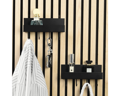 Zwei schwarze Metall-Wandregale mit Haken an einer hellen Holzlamellenwand, organisiert mit Parfüm, Schlüsseln und Kleidung in hellem Ambiente.
