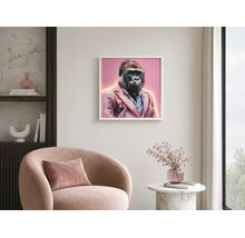 Hell gestalteter Raum mit gerahmtem Gorilla-Bild im Sakko, einem Sessel und einem Beistelltisch mit Blumen.