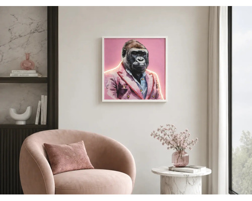 Hell gestalteter Raum mit gerahmtem Gorilla-Bild im Sakko, einem Sessel und einem Beistelltisch mit Blumen.