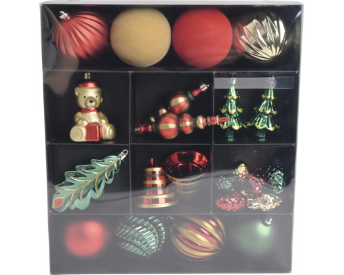 Set mit roten, goldenen und grünen Christbaumkugeln und Christbaumschmuck wie Bär, Tannenbaum, Blatt und Glocke in einer Box.