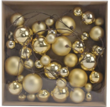 Goldene Weihnachtskugeln in verschiedenen Größen, glänzend und matt, an braunen Zweigen in einer Schachtel.