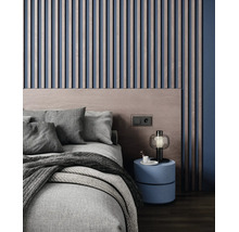Modernes Schlafzimmer mit vertikalen Wandpaneelen aus Holz, einem Holzkopfteil, texturiertem Bett und einem runden Nachttisch mit Lampe.