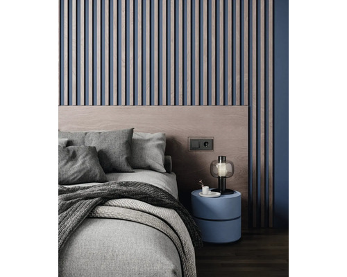 Modernes Schlafzimmer mit vertikalen Wandpaneelen aus Holz, einem Holzkopfteil, texturiertem Bett und einem runden Nachttisch mit Lampe.