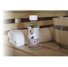 Flasche Saunaduft Eukalyptus, 250 Milliliter, auf einer Saunabank aus Holz neben einem Handtuch und einem Holzkübel.