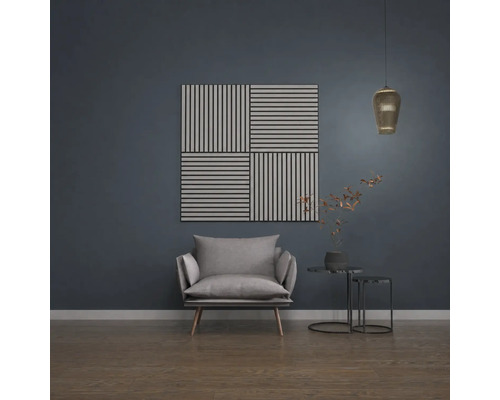 Akustikpaneele mit Streifenmuster an einer dunklen Wand in einem modern eingerichteten Wohnzimmer mit Sessel und Beistelltisch.