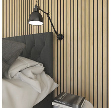 Wandpaneel aus Holzlamellen im Schlafzimmer hinter einem gepolsterten Kopfteil mit einer verstellbaren Wandleuchte.