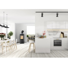 Moderner, offener Wohnbereich mit Kaminofen, integrierter Küche, Essbereich und Terrasse in hellem, minimalistischem Design.