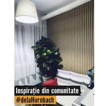 Modernes Wohnzimmer mit vertikaler Holzlamellenwand, großer Zimmerpflanze, hellen Vorhängen und einem Sofa mit gestreiften Kissen.