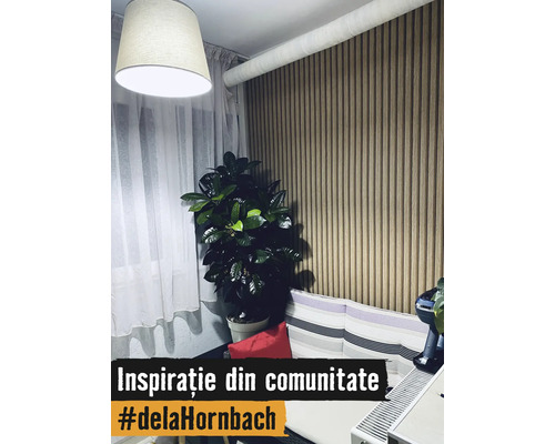 Modernes Wohnzimmer mit vertikaler Holzlamellenwand, großer Zimmerpflanze, hellen Vorhängen und einem Sofa mit gestreiften Kissen.
