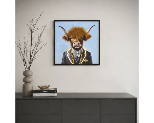 Quadratisches Wandbild mit Hochlandrind im Anzug, gerahmt, über einem Sideboard in einem modern eingerichteten Raum.