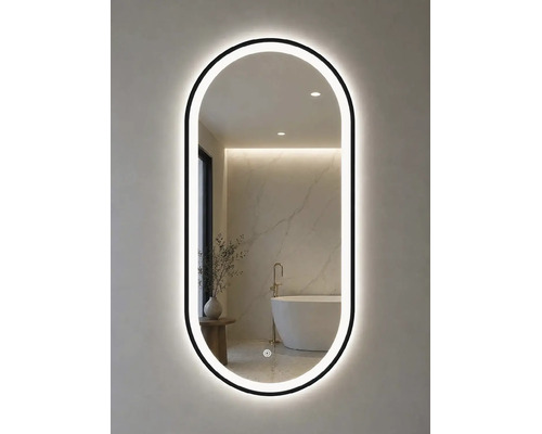Ovaler LED-Badspiegel mit schwarzem Rahmen und Touch-Sensor. Die Reflexion zeigt ein helles, modernes Badezimmer mit freistehender Badewanne.