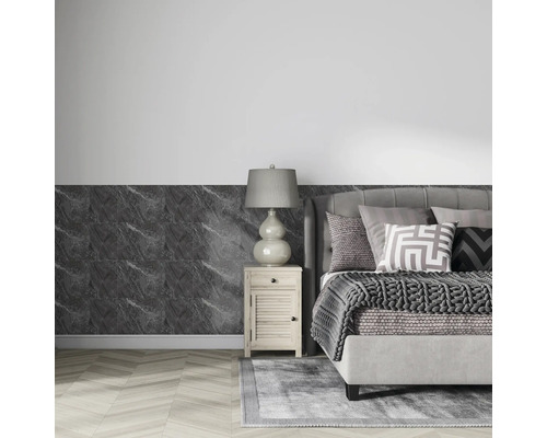 Modernes Schlafzimmer mit Wandpaneelen in dunkler Marmoroptik, grauem Polsterbett und hellem Nachttisch auf hellem Chevron-Boden.