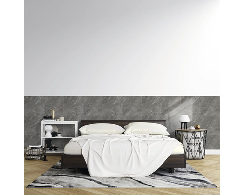 Modernes Schlafzimmer mit dunklem Holzbett. Die Wand ist halbhoch mit Fliesen in Marmoroptik verkleidet. Heller Parkettboden und gemusterter Teppich.