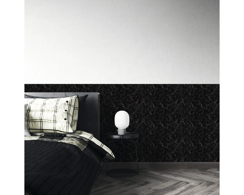 Schwarze Wandpaneele in Marmoroptik an einer Schlafzimmerwand hinter einem Bett mit Beistelltisch und Lampe.