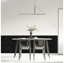 Modernes Esszimmer mit Wandfliesen in Marmoroptik, weißem Tisch, transparenten Stühlen und einer minimalistischen Pendelleuchte.