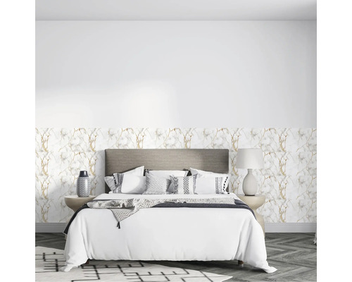 Schlafzimmer mit Vliestapete in Marmoroptik mit goldenen Adern, grauem Polsterbett, weißer Bettwäsche und Boden in Fischgrätoptik.
