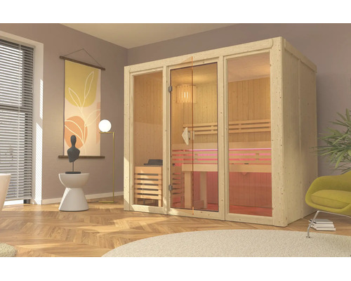 Moderne Indoor-Sauna aus hellem Holz mit Glasfront, Holzbänken und Saunaofen in einem wohnlichen Raum.