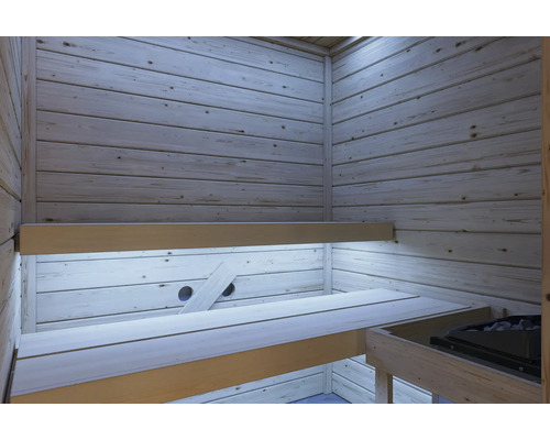 Sauna Innenansicht mit hellen Holzvertäfelungen, zwei übereinanderliegenden Saunabänken und einem integrierten Saunaofen.