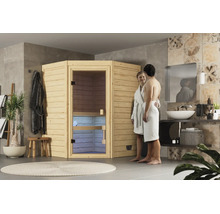 Eine Ecksauna aus Holz steht in einem modern gestalteten Badezimmer, in dem ein Paar in Bademänteln vor der Saunatür steht.