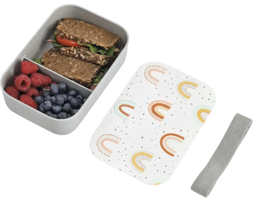 Lunchbox aus Kunststoff mit Trennwand, Deckel mit Regenbogen-Motiv und elastischem Verschlussband, gefüllt mit Brot und Beeren.