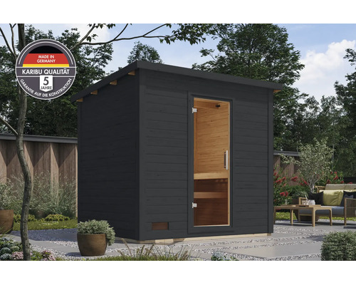 Moderne Gartensauna aus Holz mit Pultdach und Glastür in einem Garten mit Sitzbereich, inklusive Made in Germany und Garantie Siegel.