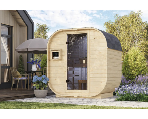 Fasssauna aus Holz mit Glastür und Steuerung auf einer Gartenterrasse in einer Außenumgebung.