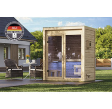 Gartensauna aus Holz mit Ganzglastür auf einer Terrasse vor einem Wohnhaus platziert