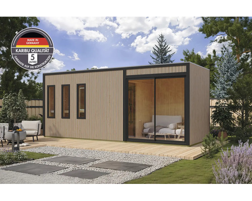 Modernes Gartenhaus mit vertikaler Holzschalung, Schiebetür und drei Fenstern auf einer Holzterrasse im Garten, inklusive Karibu Qualitäts-Siegel.