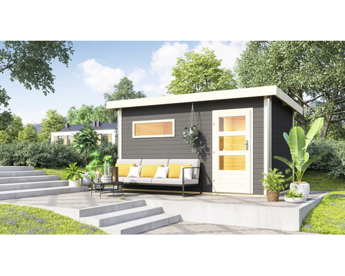 Modernes Gartenhaus mit Pultdach und verglaster Tür auf einer gepflasterten Terrasse mit Lounge Sofa und Pflanzen im Garten.