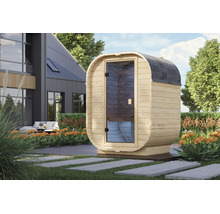 Moderne Fasssauna aus Holz mit Glastür in einem gepflegten Garten vor einem Wohnhaus.
