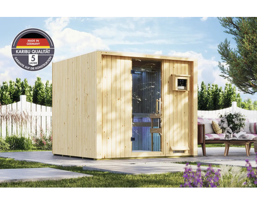 Gartensauna aus Holz mit Ganzglastür, stehend auf einer Terrasse in einem Garten mit Karibu Logo und Hinweis auf 5 Jahre Garantie.