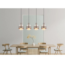 Moderne vierflammige Pendelleuchte mit Metallschirm und Glasapplikationen über einem hölzernen Esstisch mit passenden Holzstühlen im Speisebereich.