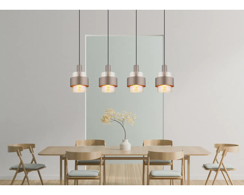 Moderne vierflammige Pendelleuchte mit Metallschirm und Glasapplikationen über einem hölzernen Esstisch mit passenden Holzstühlen im Speisebereich.