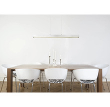 Moderne, lineare Pendelleuchte über einem Holzesstisch mit weißen Designerstühlen in einem hellen, freundlichen Esszimmer.